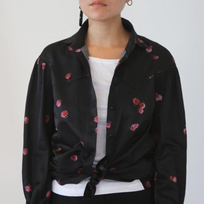 The black blouse has roses printed on the blouse and is inspired by a western, Texas style cruba. 