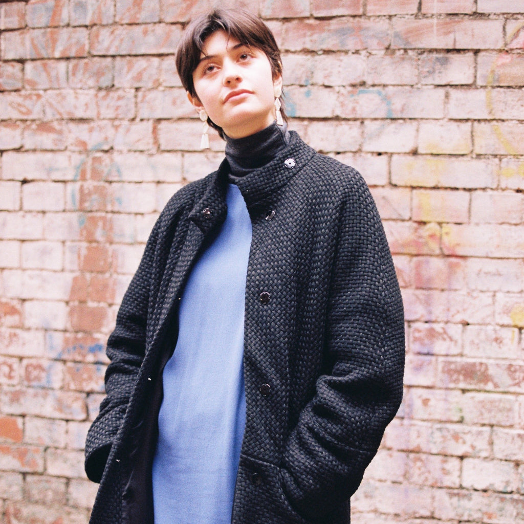 Womens merino wool jacket with sparkly effect. The jacket is layered over a blue short dress and has snap buttons to close the jacket along the front. The jacket also features two pockets at the front and warmth. cruba