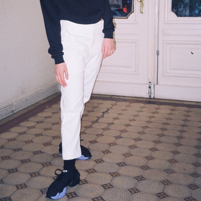 White womens pants with a high waisted stretchy fit. The pants are fair and slow fashion and produced locally. The designer is in Berlin Germany. The pants are combined with The Berlin sweater and Y3 sneakers. cruba