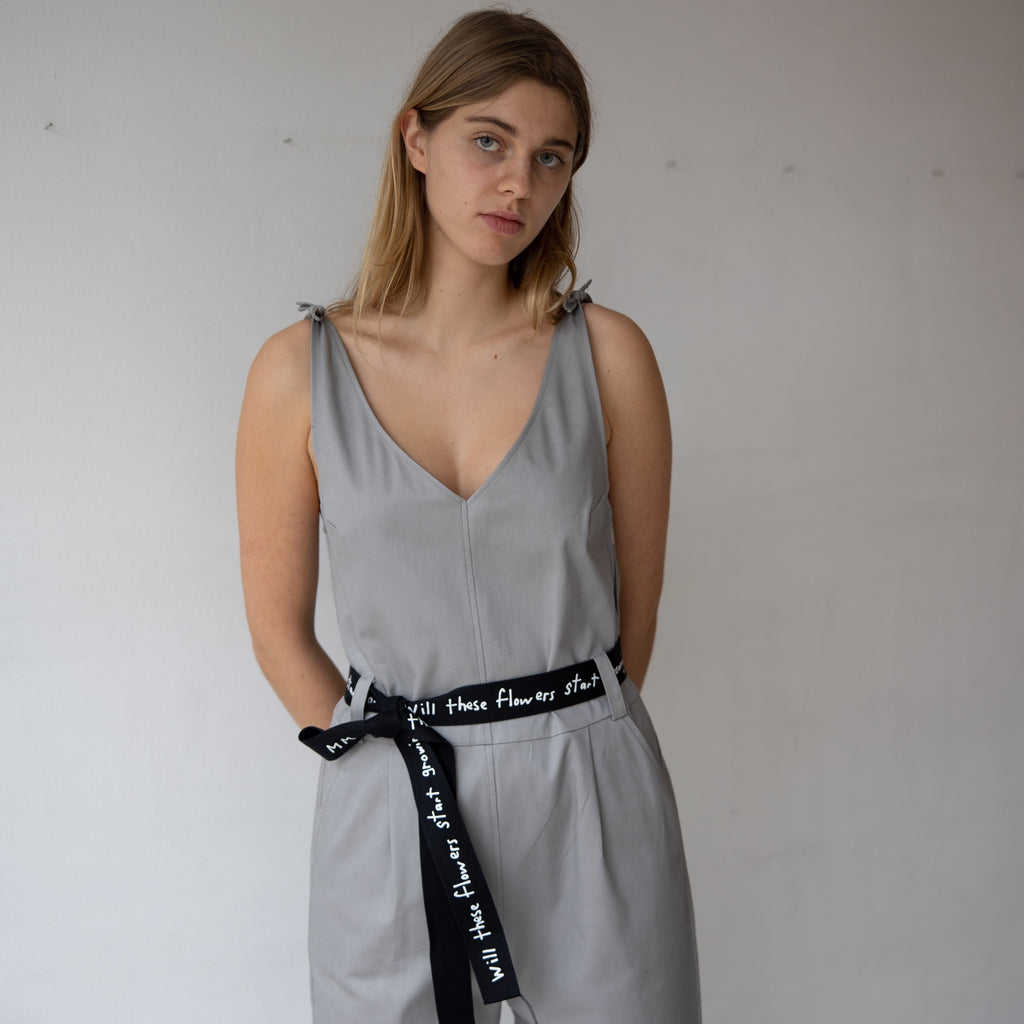 The one piece with adjustable straps features pockets in the front and in the back and the light, pastel grey color can be worn in the summer and winter. cruba