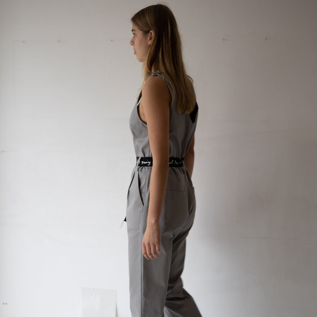 The model is wearing Chloe rain-boots in beige and the overall in a larger size for an oversized look. The one piece features a v-neck cut out in the front and an open, v-neck cut out at the back. cruba