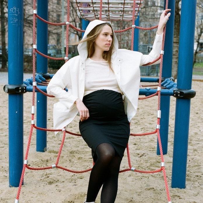 Black maternity pencil skirt with curved seam details and back support. Model wearing the shape hugging skirt and white top. cruba  Edit alt text