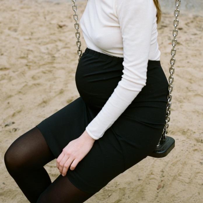 Black maternity pencil skirt with curved seam details and back support. stretchy detailing at waist. midi skirt made out of stretchy cotton. Berlin, Germany clothing independent studio. cruba