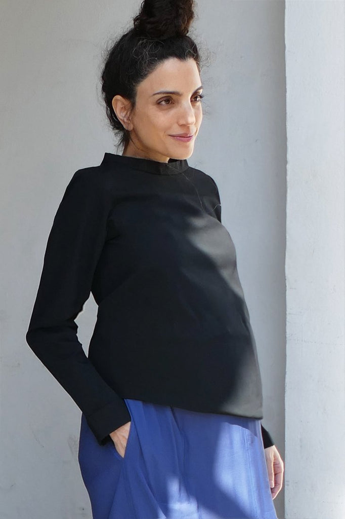 Model wearing a long maxi dress with slit and a maternity top made out of cotton. high neckline and long sleeves. feminine sustainable, locally produced blouse. cruba 